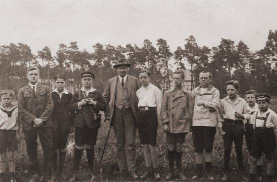 Eine Gruppe Jugendlicher auf einem Gruppenfoto. Im Hintergrund stehen Bäume des Gonsenheimer Waldes. 